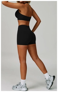 Detail of high-waist black yoga shorts and sports bra set with seamless compression
