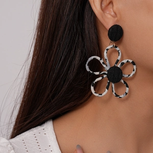 Close-up of leopard print fabric flower earrings with black stud on a female model