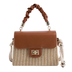 Straw box handbag with brown pleated handle and woven shoulder strap on white background