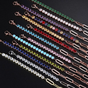 Macro detail of mixed paperclip and tennis chain bracelets with colorful zircon stones