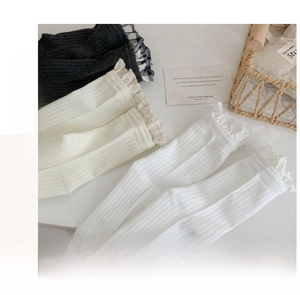 Detail of ribbed cotton mid-calf socks with delicate lace edges in black, white, and beige