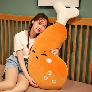 A young woman hugging a large cartoon chicken leg plush pillow in a cozy bedroom setting