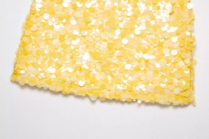 Détail macro de paillettes jaunes scintillantes pour robes de soirée et jupes élégantes