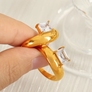 Irregular 18k gold plated ring with two square zircon stones shown on a hand