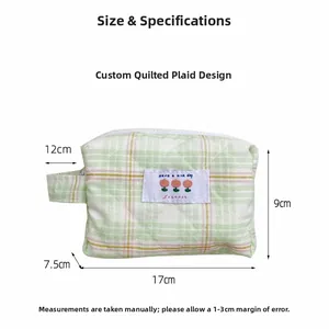 Detail of green checkered quilted pouch showing Have a nice day label and fabric texture