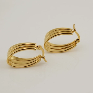 Boucles d'oreilles créoles ovales en acier inoxydable doré à trois couches sur fond blanc