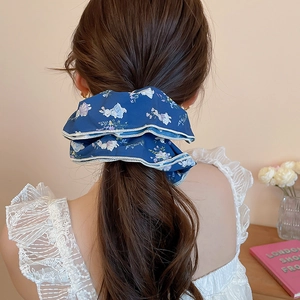 Detail of navy blue floral scrunchie with rabbit patterns on a low ponytail hair tie