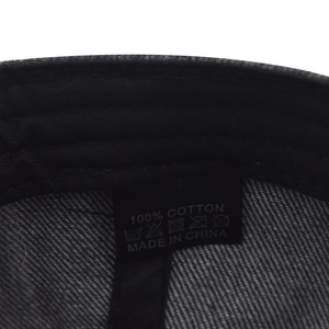 Detail view of the 100% cotton care label and stitching inside the washed denim cap