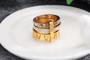 Detailed view of layered Roman numeral rings in gold with sparkling white crystals