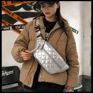 Silver quilted crossbody waist bag featuring a metallic finish on a model in street style