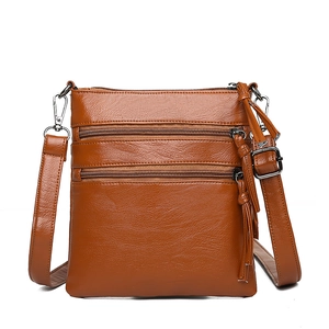 Brown soft leather crossbody phone bag with three front zip pockets and tassels