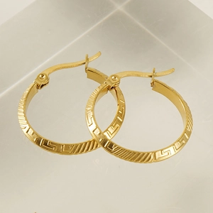 Golden titanium steel hoop earrings with Greek fret pattern on acrylic stand