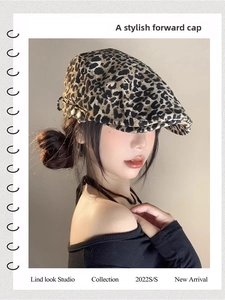 Detail view of leopard print beret featuring stylish side gold buttons and retro fabric