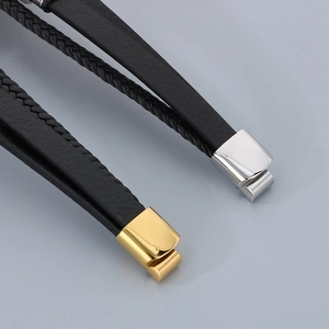 Detail of woven black leather bracelet showing gold and silver magnetic metal clasps