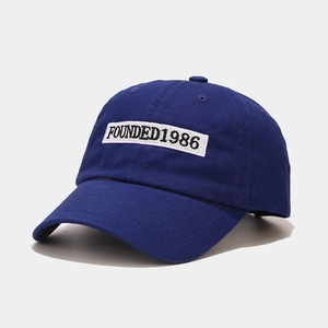 Detail of navy cotton baseball cap featuring high-quality 1986 embroidery and six-panel crown