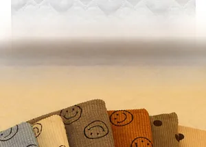Macro detail of ribbed corduroy fabric texture and minimalist smiley face pattern embroidery