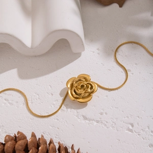 Elegant vintage rose pendant necklace with gold snake chain for women on stone background