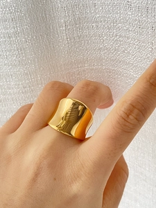Close-up of wide 18K gold plated titanium steel ring with smooth irregular surface