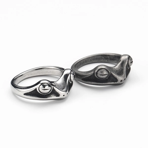 Detail of silver and vintage grey frog rings showing intricate metal textures and finishes