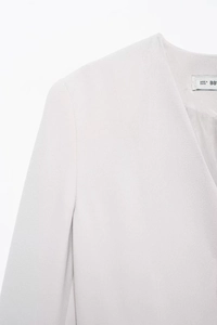 Detail view of grey V-neck blazer showing shoulder seam and soft fabric texture