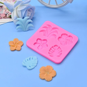 Pink silicone mold featuring tropical leaf and hibiscus flower shapes for fondant and clay