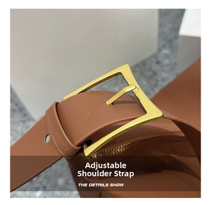 Close-up of caramel brown leather shoulder strap with adjustable gold buckle detail