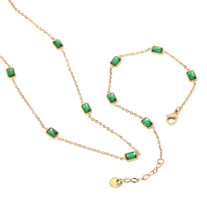 Golden titanium steel necklace with rectangular emerald zircon stones on white background