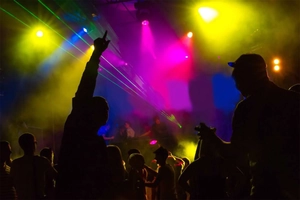 Dynamic party scene with silhouette crowd dancing under colorful RGB stage laser lights