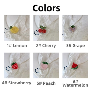 Macro detail of cute acetate fruit hair clips in lemon, cherry, grape, and strawberry shapes