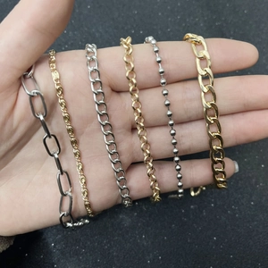 Flat snake and curb chain bracelets in gold and silver finish on hand