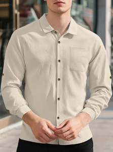 Detailed texture of men's beige linen shirt featuring single chest pocket and button cuffs