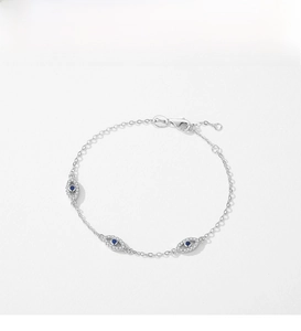 Macro shot of silver evil eye bracelet with blue stones and cubic zirconia detailing