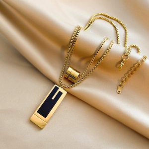Detail of double-layer steel sweater necklace with black pendant on champagne silk