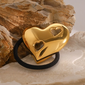 Polished golden hollow heart hair tie on a mineral stone base with black elastic band