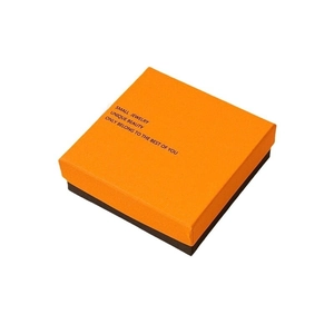 Elegant two-tone jewelry gift box in orange and black with minimalist gold lettering