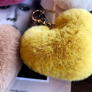 Close-up of leopard heart fluffy keychains with golden ring on fashion background