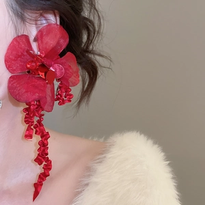 Detail of red fabric flower earring featuring sparkling sequins and elegant long tassels