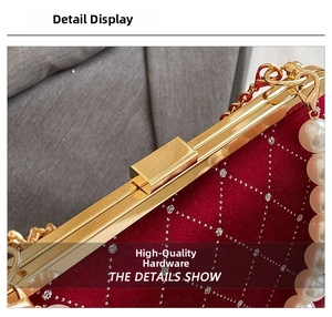 Macro shot of red velvet evening bag with silver diamond lattice and pearl handle
