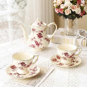 Service à thé en céramique vintage avec motifs floraux rouges et bordure dorée élégante