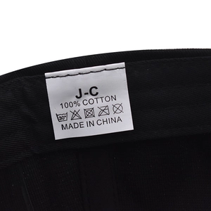 Detailed macro view of the 100% cotton wash label on the black baseball cap inner band