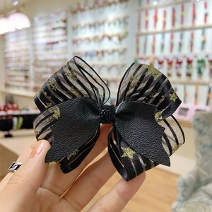 Detail of creative Halloween bow hair clip featuring star pattern mesh and black faux leather