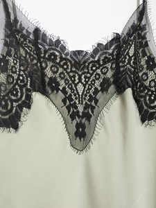 Detail of V-neck lace trim and silky satin fabric on a split camisole maxi dress