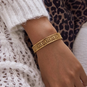 Detail of vintage 18K gold plated lace hollow cuff bracelet on a female wrist