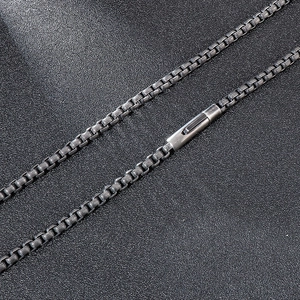 Macro close-up of dark grey square box chain and spring clasp made of vintage titanium steel
