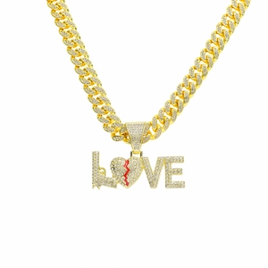 Iced out gold Cuban link necklace with LOVE letter pendant and red broken heart detail