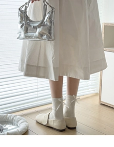 Close-up of ribbed cream white crew socks with decorative bow detail and Mary Jane shoes