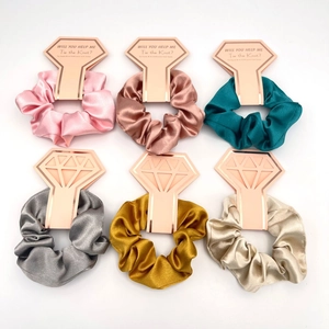 Detail of six colorful satin scrunchies on diamond-shaped cards for wedding party gifts