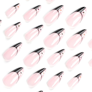 French black tip almond press-on nails with white flower patterns and small rhinestones