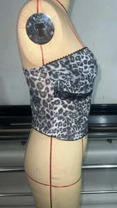 Detail view of leopard print tube top with black lace trim on side of a mannequin