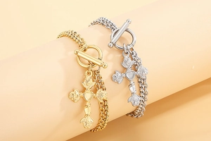 Detail of multi-row stainless steel bracelet with rose cross charms and OT toggle clasp